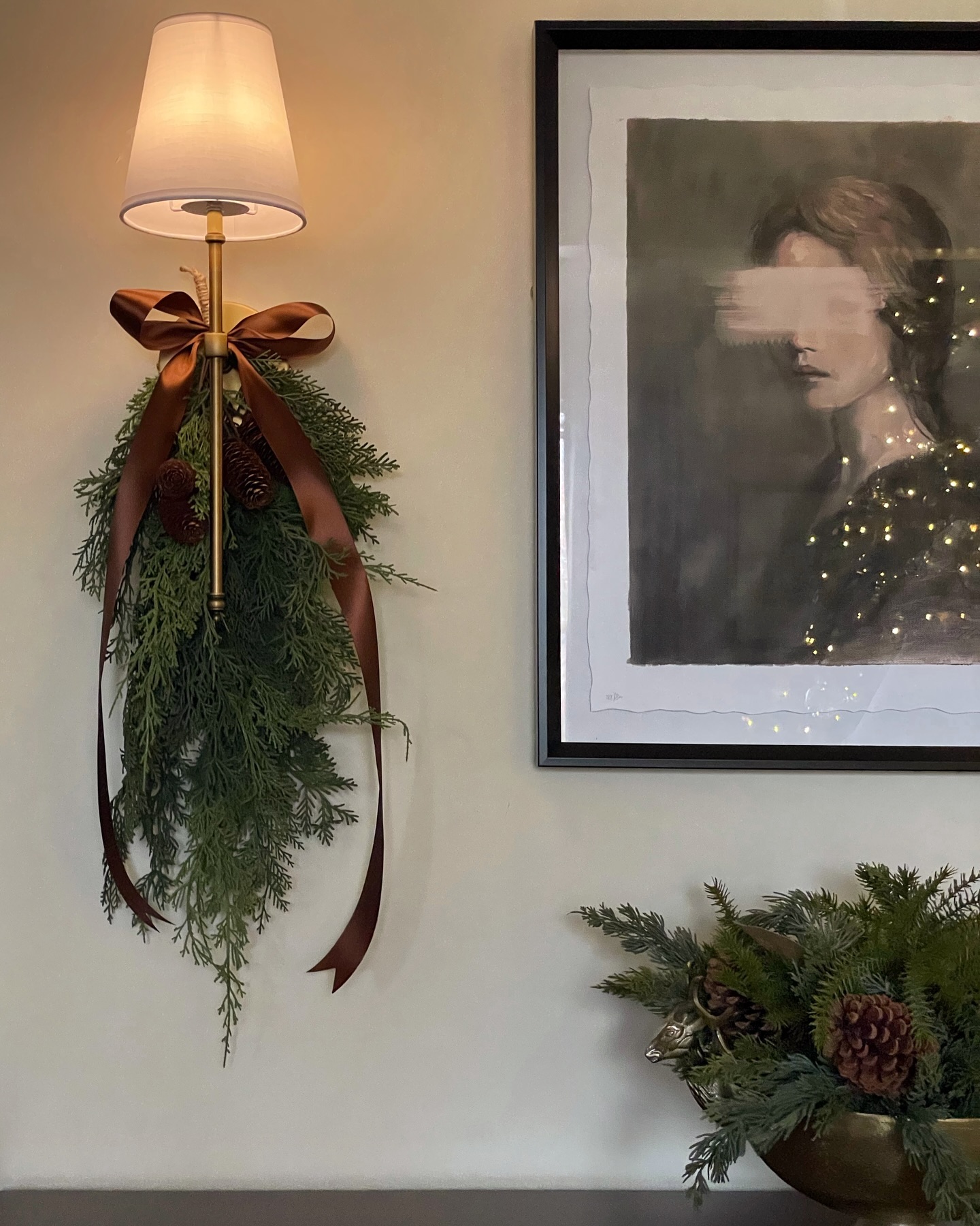 greenery tied to wall lamp in holiday theme budget Christmas decorating ideas