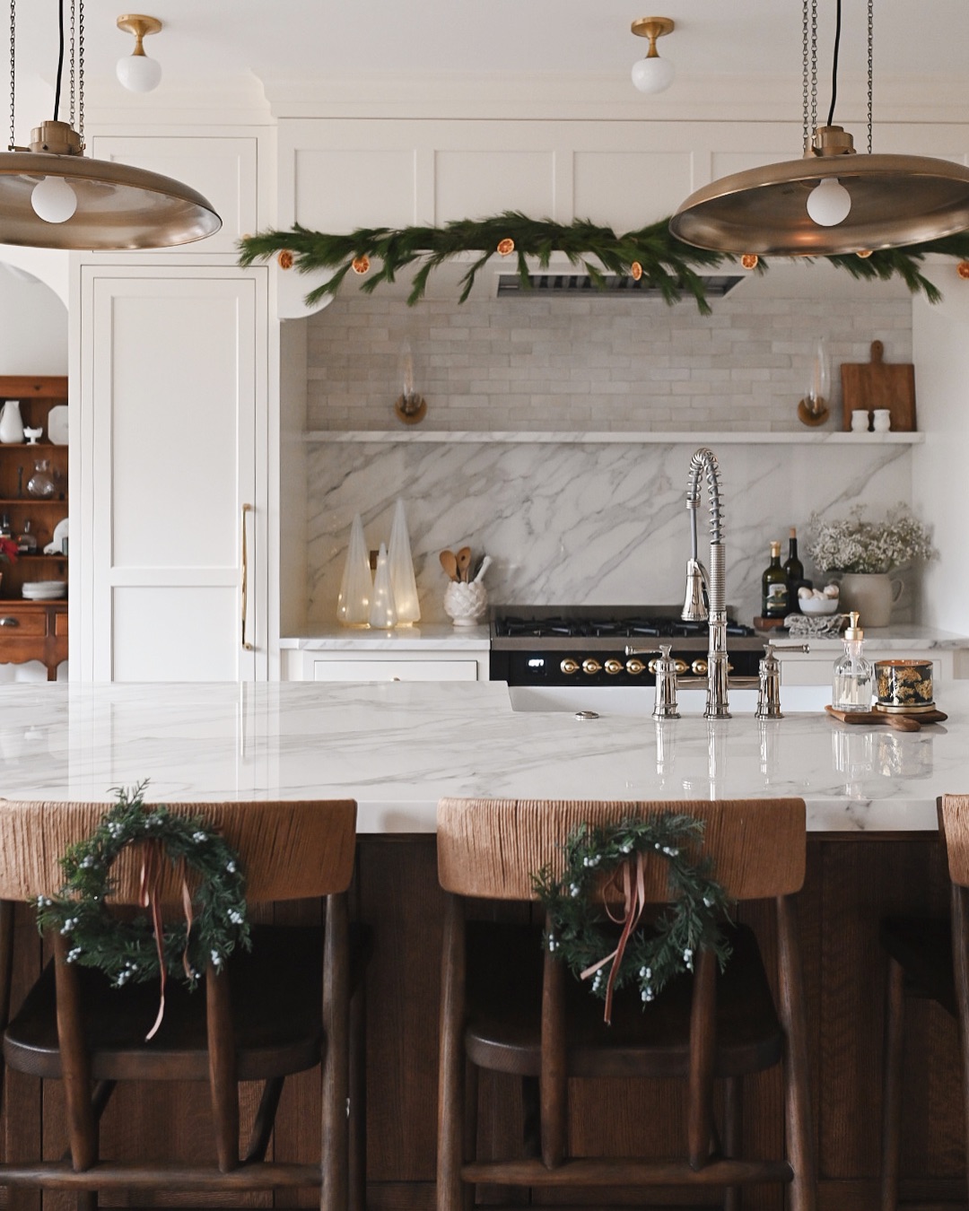 Budget Christmas kitchen styling tips and ideas featuring wreaths hanging from the back of chairs
