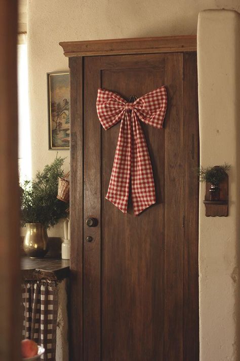 Budget Christmas kitchen styling tips and ideas featuring large bow hanging from wooden door