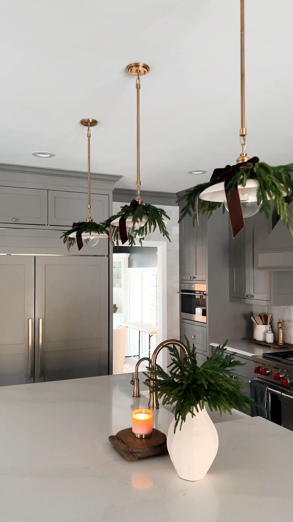 Budget Christmas kitchen styling tips and ideas featuring pendant lights with decorative greenery