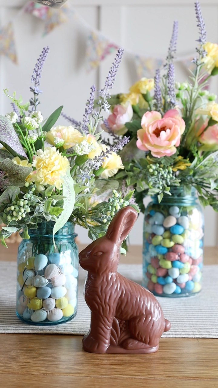mason jar with eggs and flowers with a chocolate easter bunny in a vignette