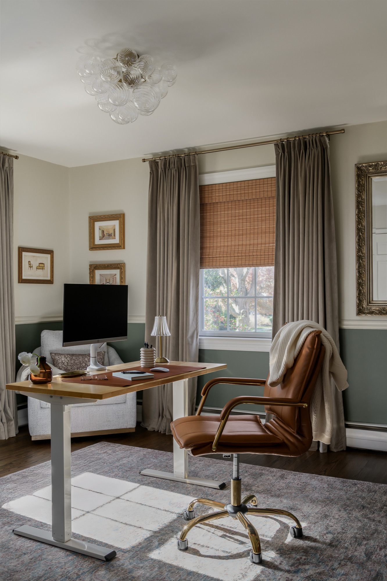 Home office with sage green walls and a leather swivel chair in a colonial home tour