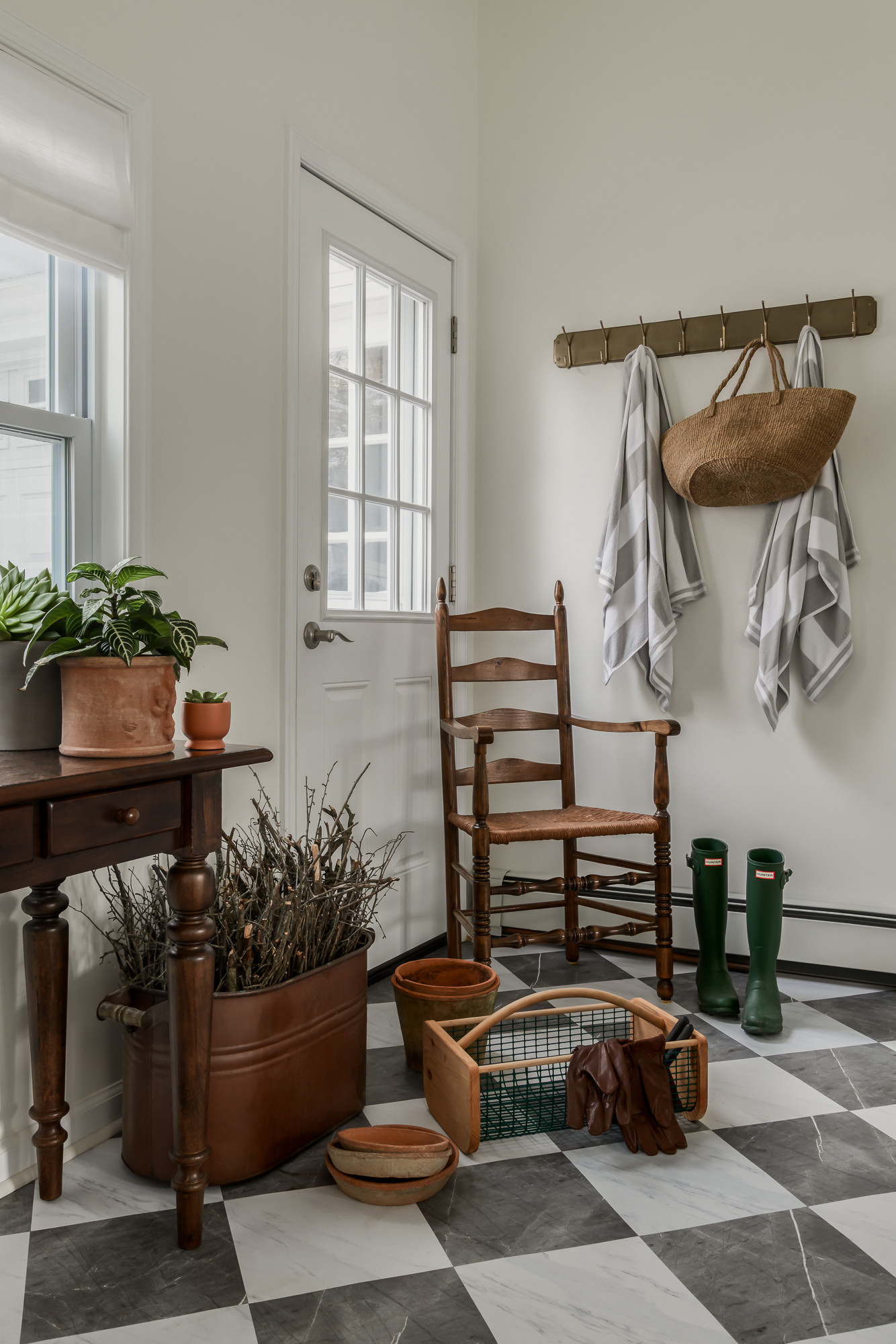 Back entry with checkerboard floors and a peg rail in a colonial home tour