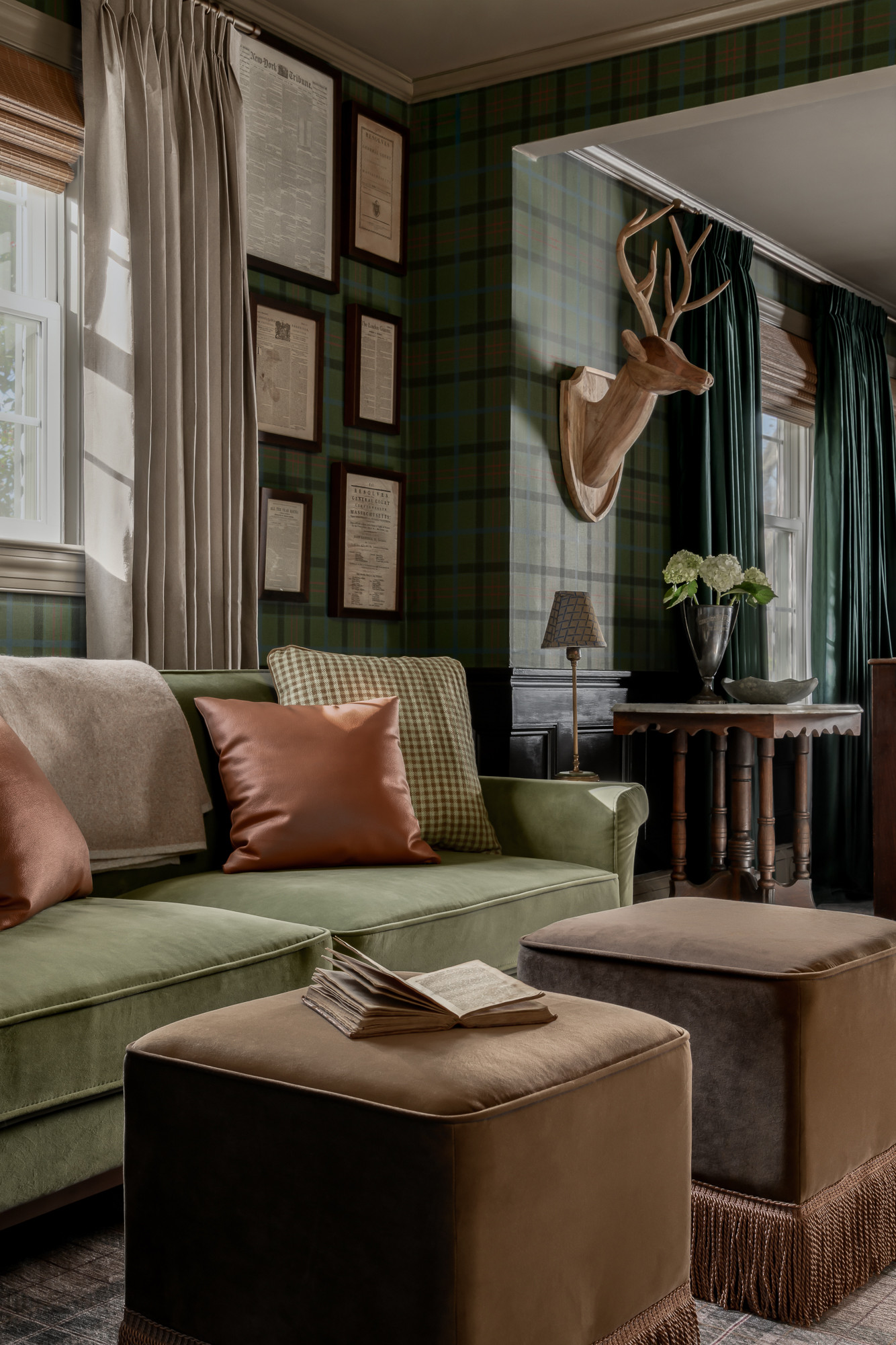 Library with olive velvet sofa and floor-to-ceiling bookshelves in a colonial home tour