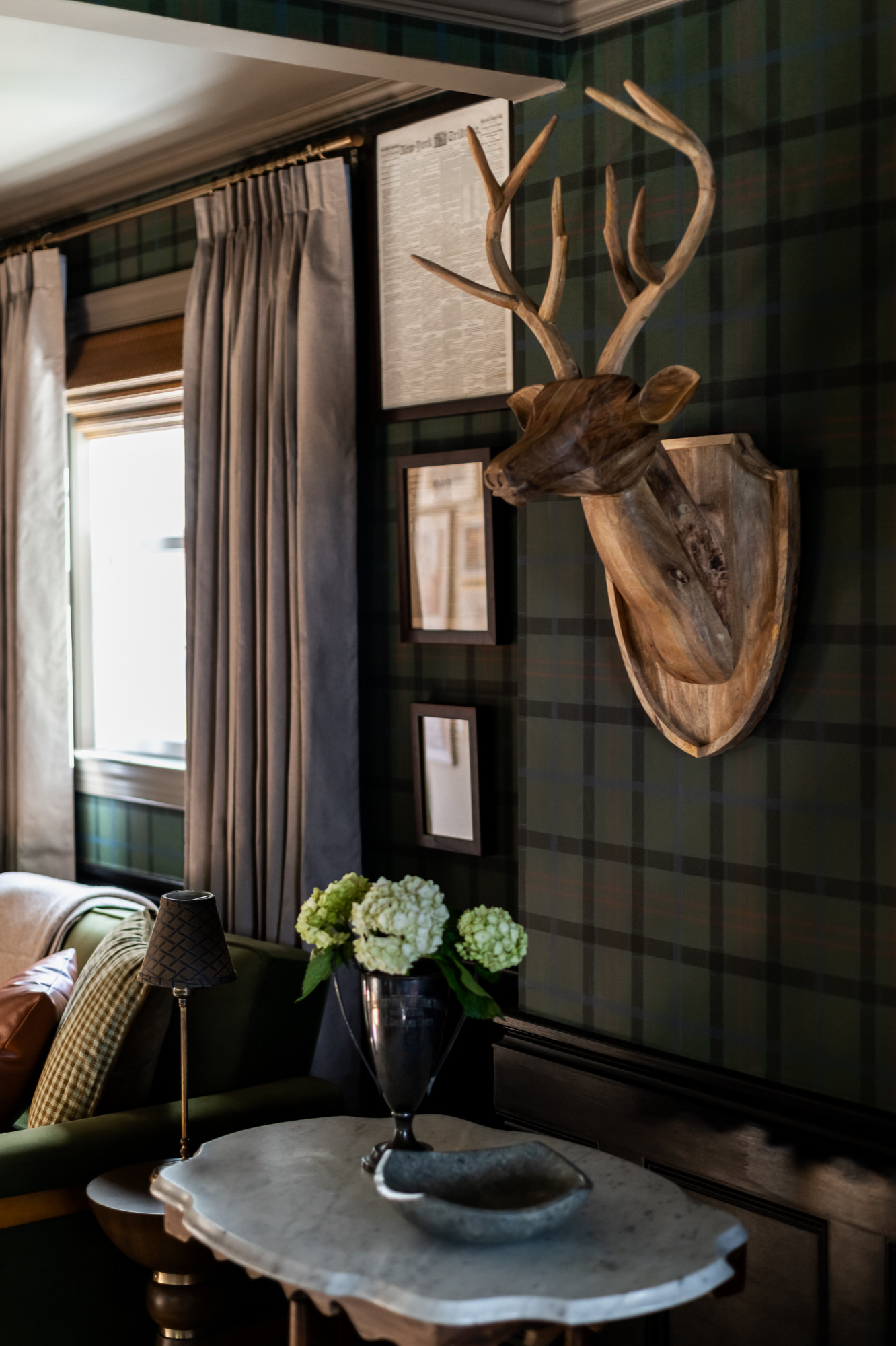 Sitting corner with green plaid wallpaper and emerald velvet drapery in a colonial home tour
