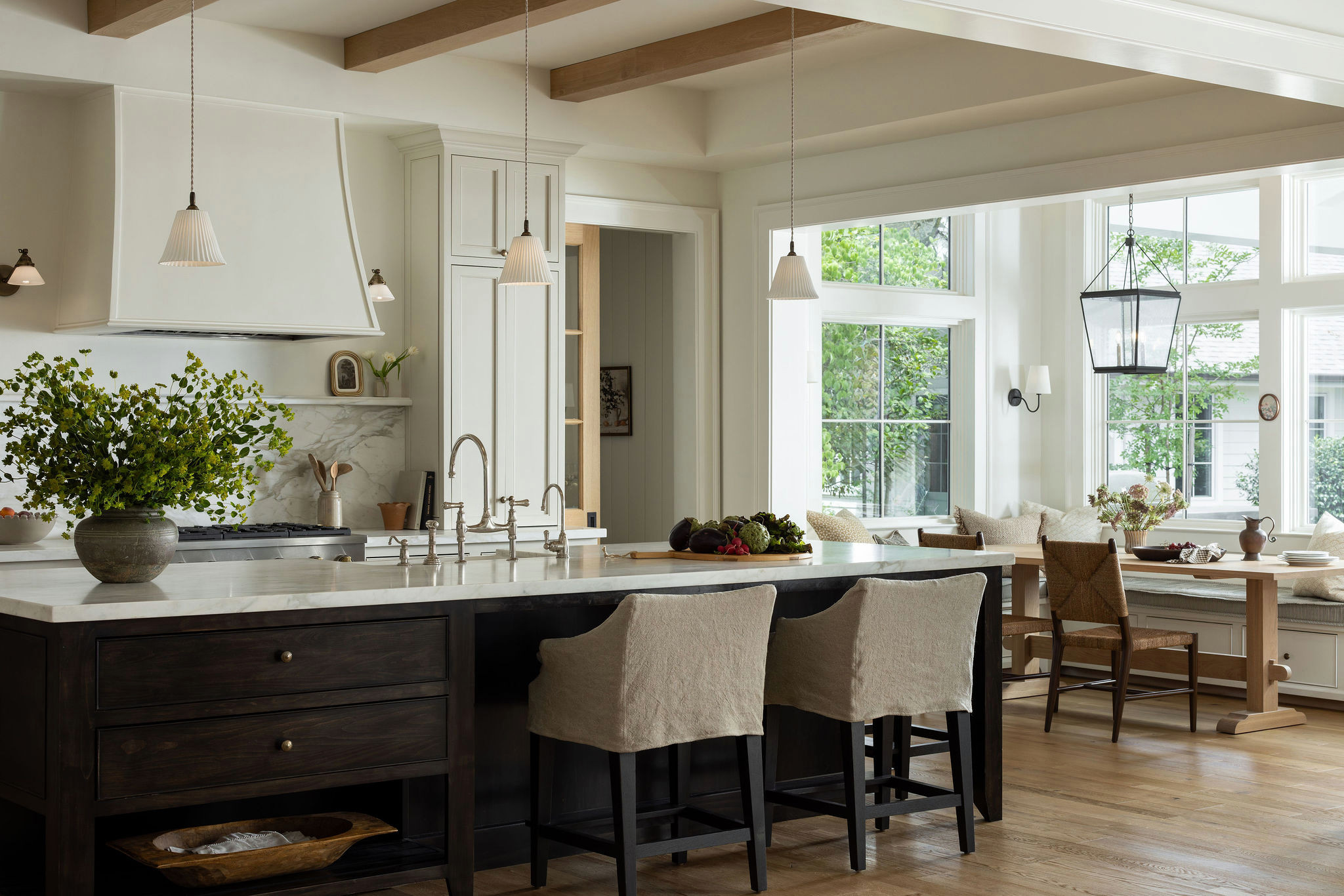 Kitchen with dark wood island and oak ceiling beams in a traditional home tour
