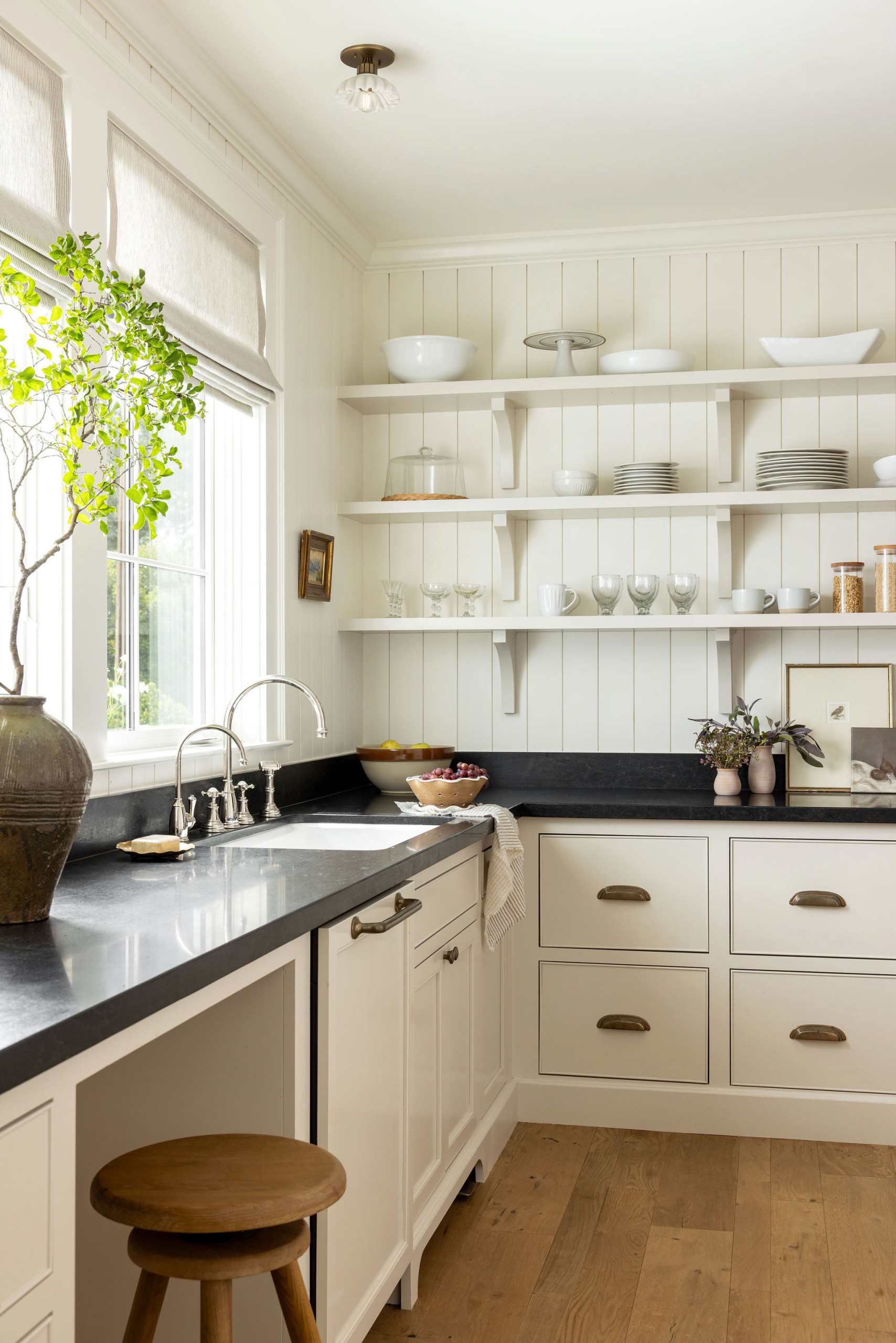 Kitchen with dark wood island and oak ceiling beams in a traditional home tour