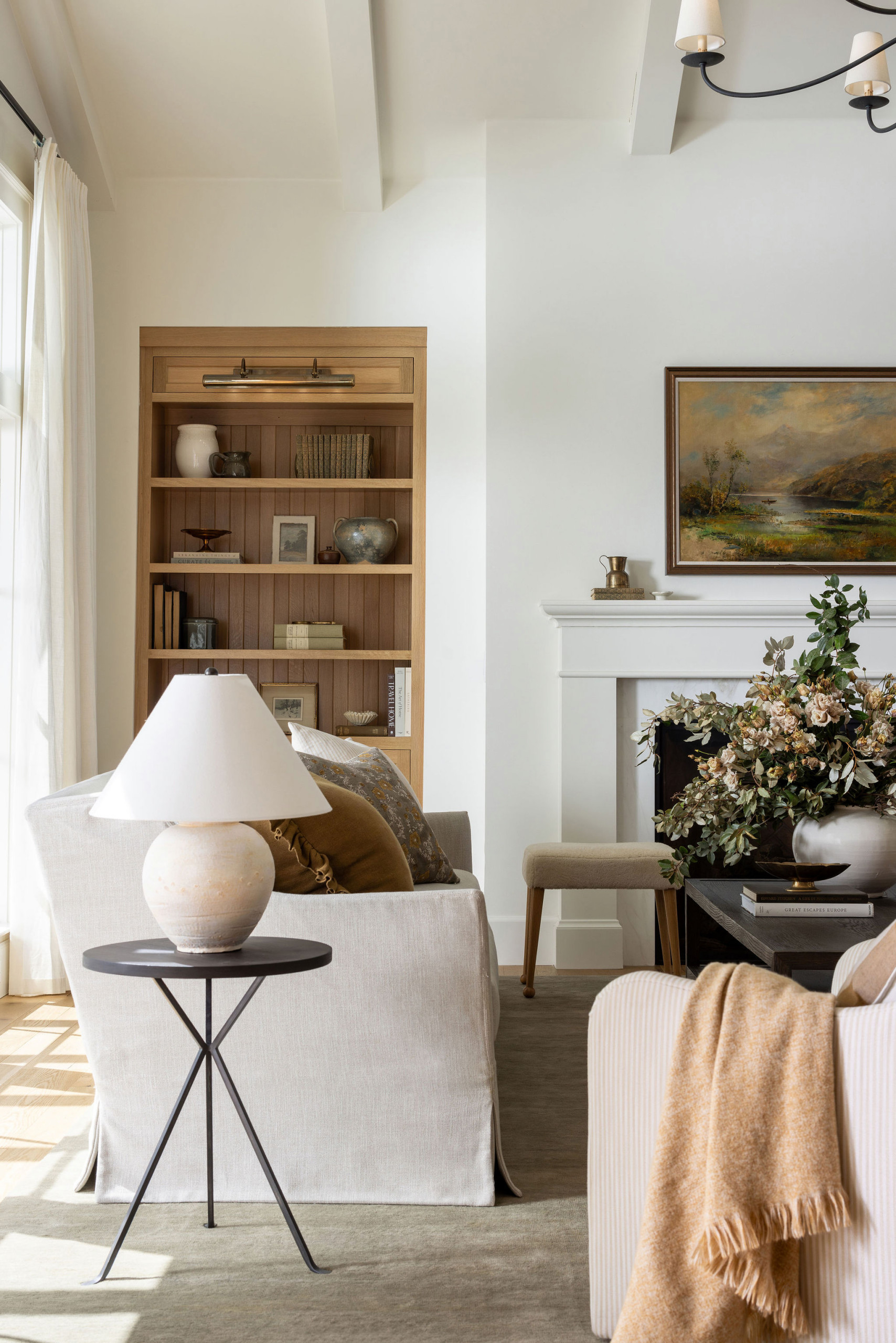 Living room with white fireplace and oak built-ins in a traditional home tour