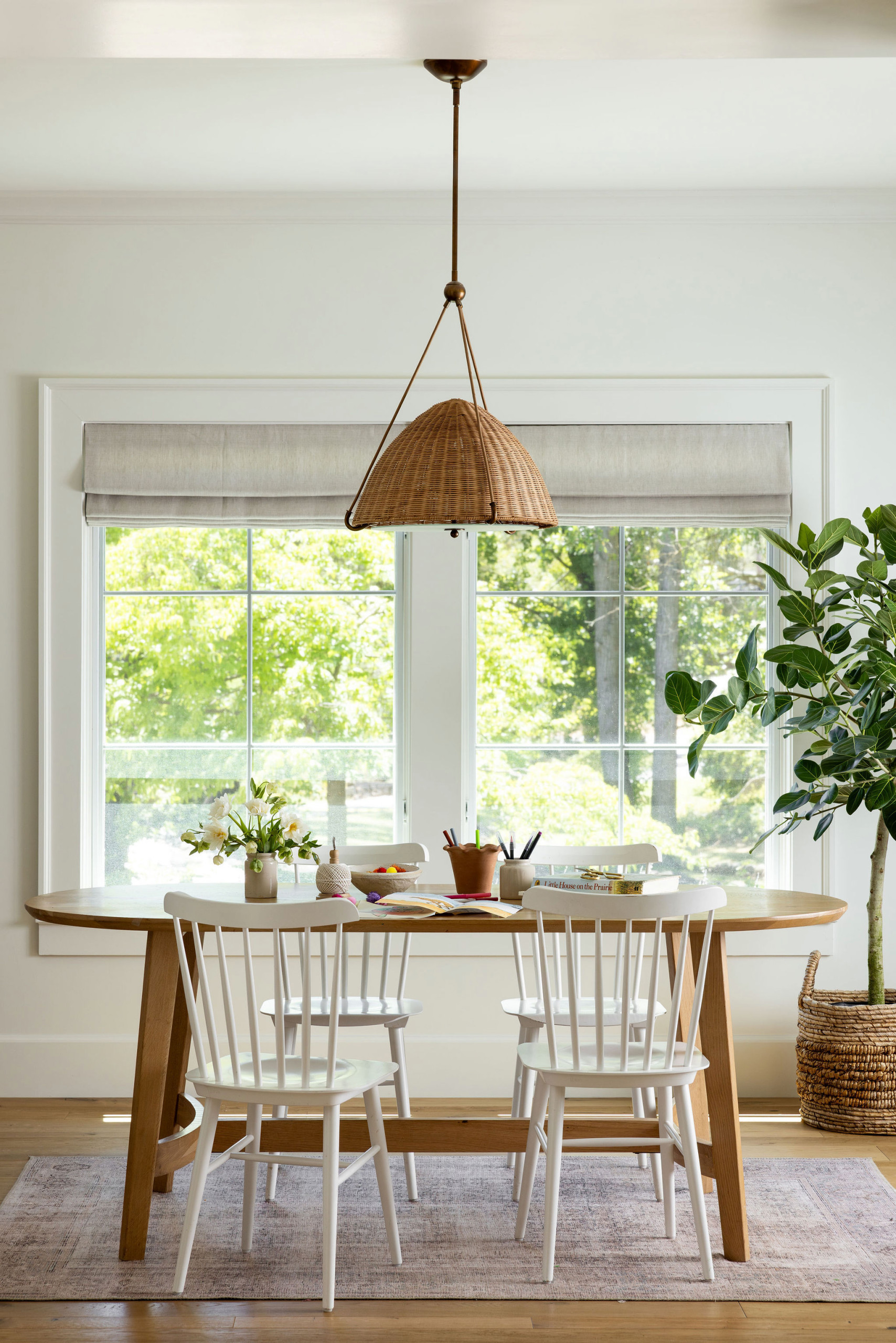 Breakfast room with round oak table and rattan pendant in a traditional home tour