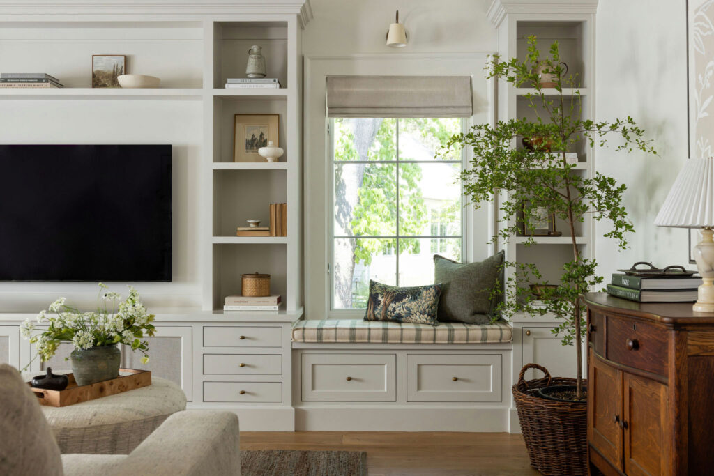 Family room with painted media wall built-ins and cream sofa in a traditional home tour
