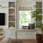 Family room with painted media wall built-ins and cream sofa in a traditional home tour
