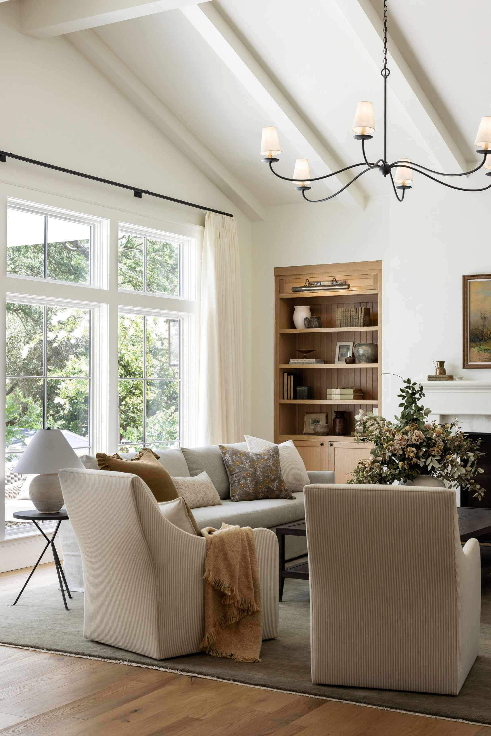 Living room with white fireplace and oak built-ins in a traditional home tour