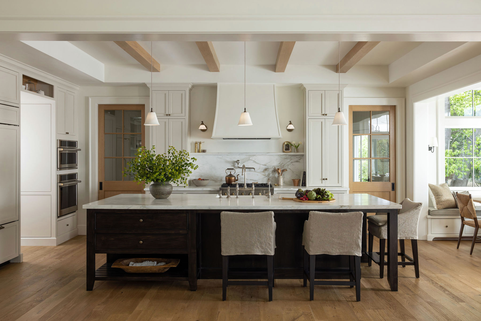 Kitchen with dark wood island and oak ceiling beams in a traditional home tour