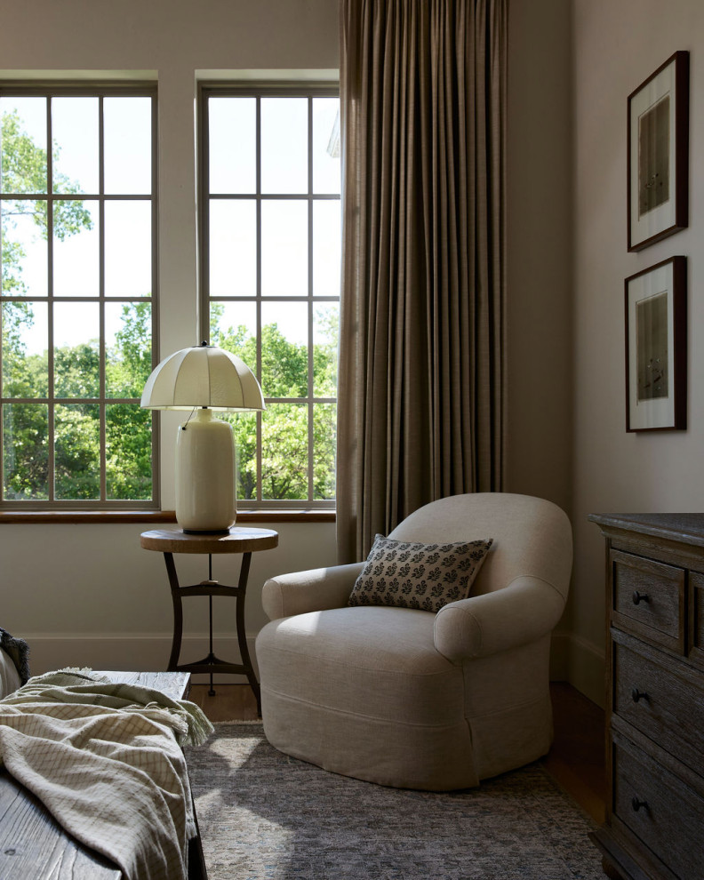 Mountain home tour bedroom reading corner with a slipcovered linen chair, small side table, and scalloped lamp.