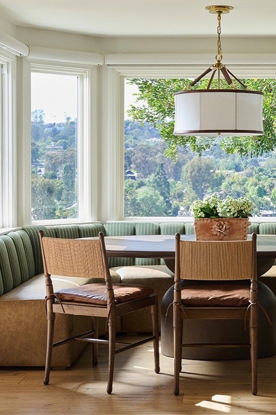 Breakfast nook with a striped banquette and leather-trimmed pendant in a Mediterranean home tour